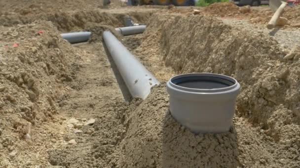 CLOSE UP: Dark grey fresh cement covers pipes of a wastewater drainage system. — Stock Video
