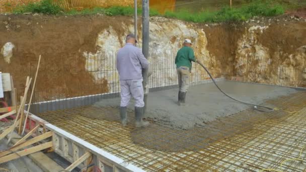 Załoga doświadczonych budowniczych wylewa betonową płytę na placu budowy. — Wideo stockowe