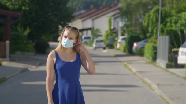 Het meisje midden op straat gooit haar gezichtsmasker weg.. — Stockvideo