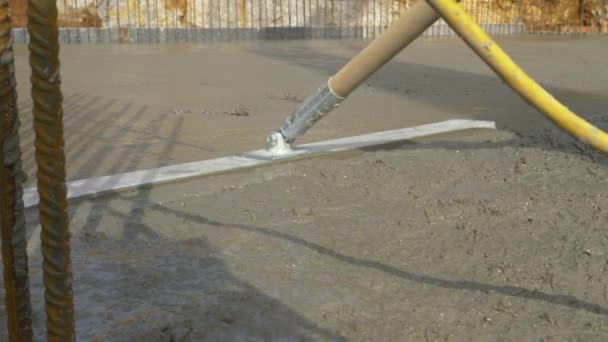 CERRAR: Trabajador irreconocible utiliza una herramienta de nivelación para extender el mortero fresco — Vídeo de stock