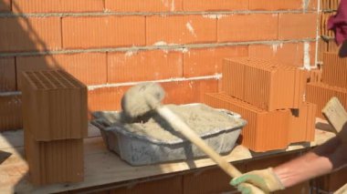 Tanınmayan tuğla ustası bir konteynırı taze havan topuyla dolduruyor..