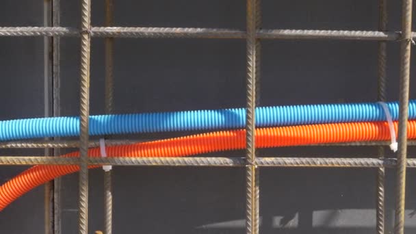 CERRAR: Dos tubos detrás del cableado metálico oxidado y a lo largo de la pared negra. — Vídeo de stock