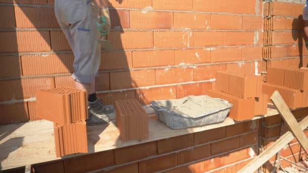 FERMER : Les travailleurs parlent et se tiennent debout tout en posant des briques sur le chantier de construction — Video