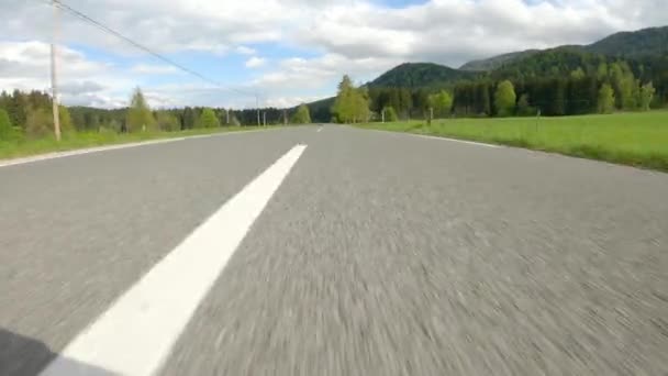 POV : Accélérer sur une route vide traversant une belle vallée verte par une journée ensoleillée. — Video