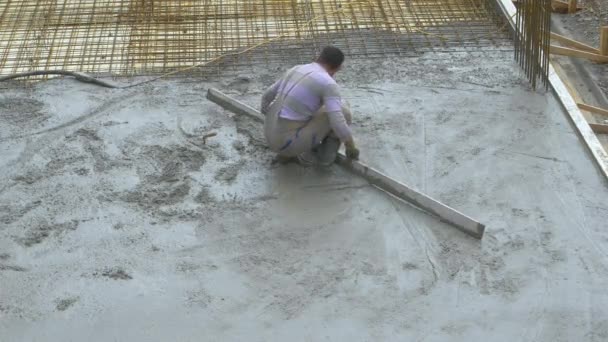 CHIUSURA: L'imprenditore esperto diffonde cemento fresco che copre il terreno. — Video Stock