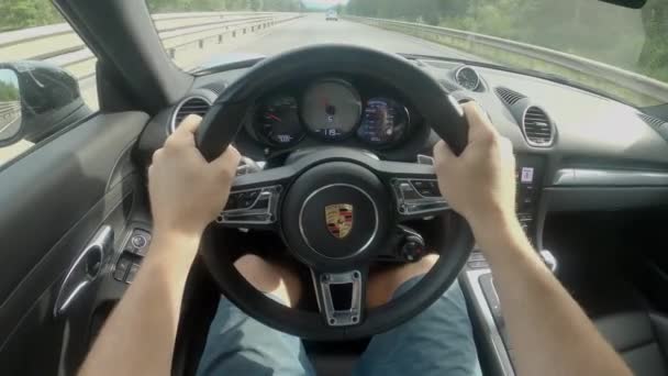 POV: Man rijdt over de lege snelweg in een gloednieuwe Porsche supercar. — Stockvideo