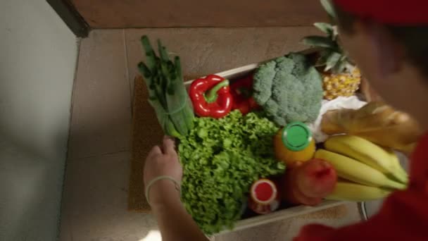 Felismerhetetlen kézbesítő egy doboz élelmiszert hagy a küszöbön.. — Stock videók