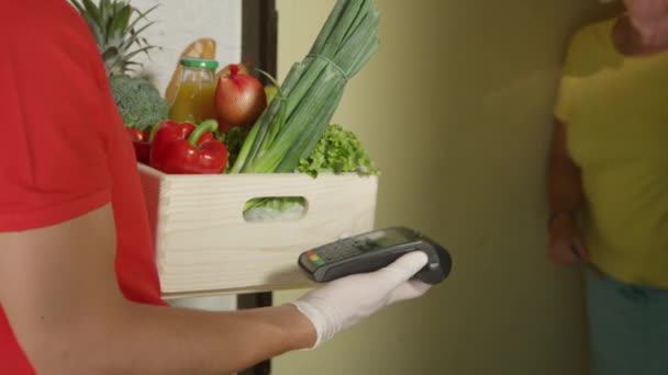 CERRAR: Mujer mayor utiliza una tarjeta de crédito para pagar su entrega de comestibles. — Vídeo de stock