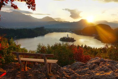 Güzel turuncu akşam güneşleri yalnız ahşap bankta parlıyor..