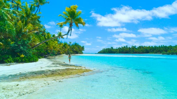 AERIAL: Ung kvinnlig turist i bikini promenader längs den vita sandstranden. — Stockfoto