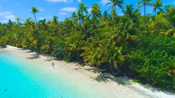 DRONE: Mladá cestovatelka kráčí po bílém písečném břehu exotického ostrůvku — Stock fotografie