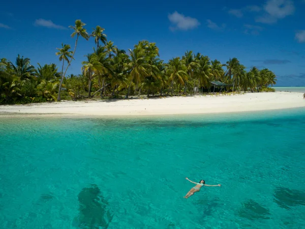 Menina relaxada a flutuar na superfície tranquila do oceano azul-turquesa. — Fotografia de Stock