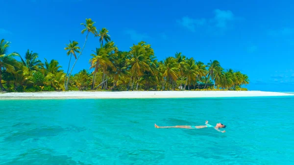 AÉRIAL : S'envoler loin de la jeune femme se détendre dans l'eau cristalline de l'océan. — Photo