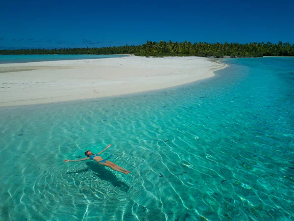 AERIAL: Carefree young Caucasian woman relaxing in the crystal clear water. — Stock Photo, Image