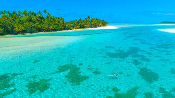 DRONE: Carefree young woman swimming on her back in the exotic turquoise sea. — Stock Photo, Image