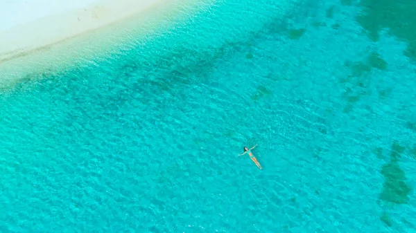 TOP DOWN: Relaxada jovem mulher esfriando flutuando no oceano azul-turquesa. — Fotografia de Stock