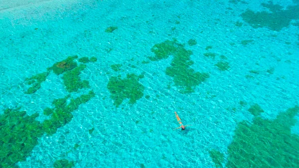 Volare via da una donna appoggiata sulla sua schiena sulla superficie dell'oceano — Foto Stock