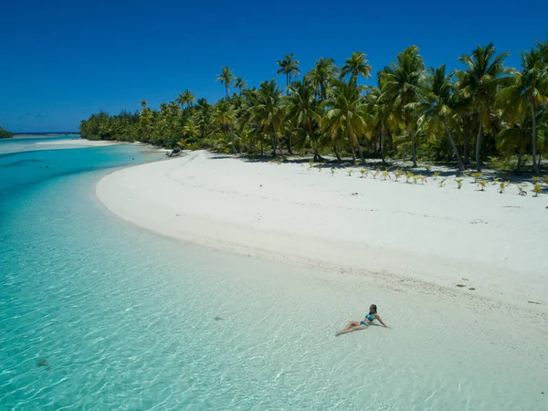 AÉRIAL : Jeune femme se relaxant dans l'eau vitreuse de l'océan près de l'île exotique luxuriante — Photo