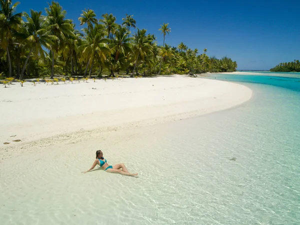 AERIALE: Giovane donna che si gode la vacanza prendendo il sole sulla spiaggia esotica. — Foto Stock