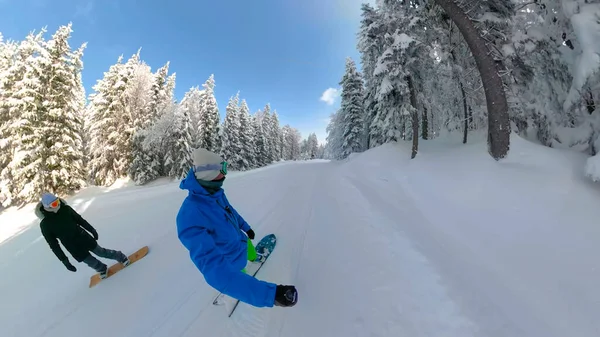 SELFIE : Cool snowboarders masculins et féminins snowboard sur la pente damée. — Photo