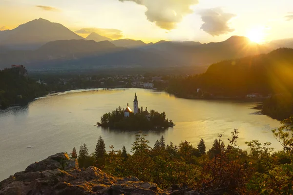 AEREO: Raggi di sole della sera dorati splendono sul pittoresco isolotto del lago di Bled. — Foto Stock