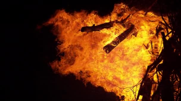 VERTICAL, CLOSE UP: Brandende hete vlammen overspoelen een grote stapel brandhout. — Stockvideo