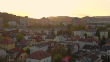 Güneşli bir sonbahar akşamında Ljubljana 'da bir yerleşim bölgesinin üzerinde uçuyor..