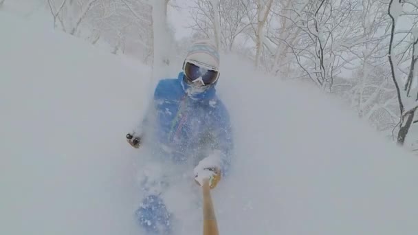 SELFIE: Pro skiër versnipperen van de vers gevallen sneeuw tijdens het rijden in het achterland. — Stockvideo