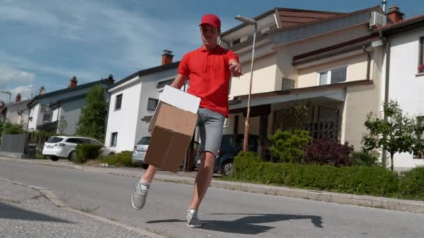 HELYES ANGLE: Óvatlan fiatal futár rugdossa ügyfelek megrendelések a küszöbön. — Stock videók