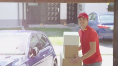 Teslimatçı, güneşli bir günde birinin garaj yoluna paket atar..