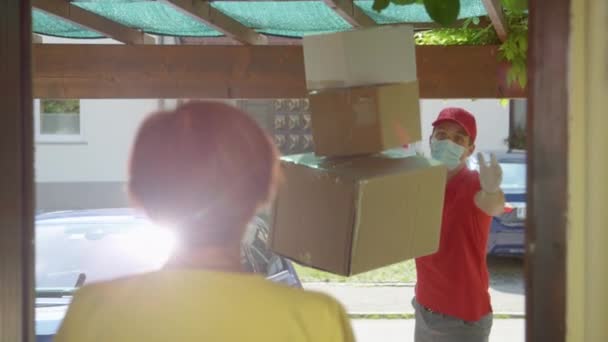 FECHAR UP: mensageiro descuidado lança pacotes para senhora sênior abrindo a porta — Vídeo de Stock