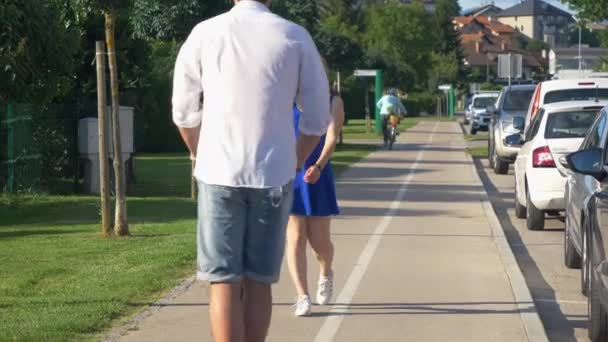 FECHAR UP: Man riding electric scooter waves off girl walking down sidewalk. — Vídeo de Stock