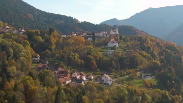AERIAL: Piękny widok na idylliczną górską wioskę w malowniczy jesienny dzień. — Wideo stockowe