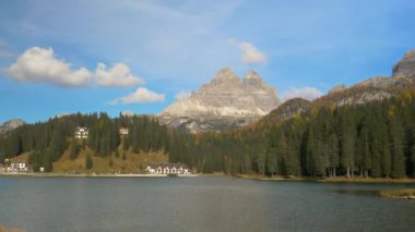 Lago di Misurina 'nın göl kıyısındaki turistik tatil beldelerini çevreleyen renkli sonbahar manzaraları.
