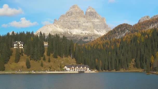 Duży hotel nad jeziorem w Dolomitach otoczony jest pięknym jesiennym krajobrazem — Wideo stockowe