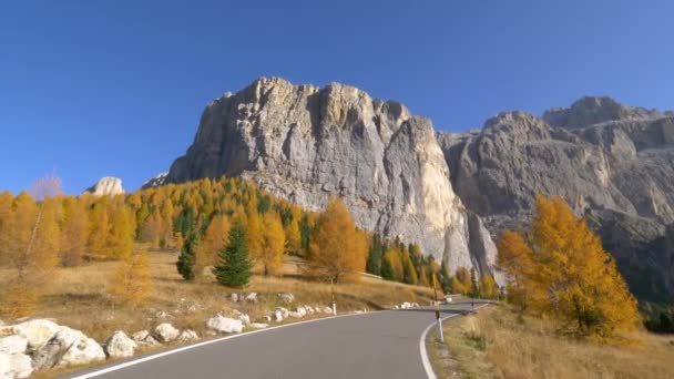 POV: Cinematic shot of an empty asphalt road running under Tre Cime in autumn. — Stock Video