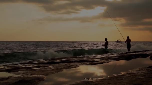 Fischer fischen bei Sonnenuntergang am Strand — Stockvideo