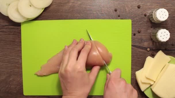 Женские руки режут куриное филе — стоковое видео