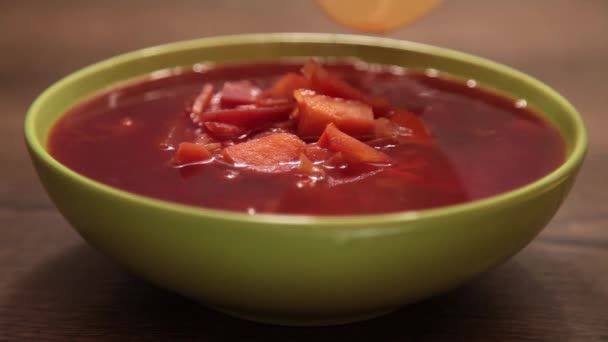 緑の皿の中のおいしい赤いボルシチ — ストック動画