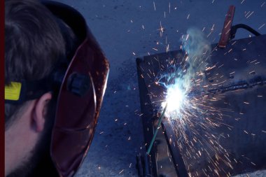 Elektrikli kaynaktan flaş. Işıktan koruyucu maskeli adam