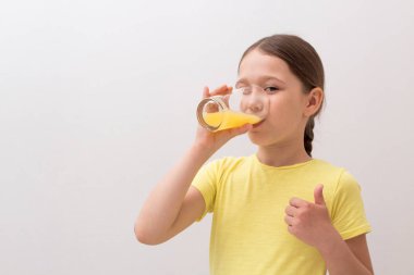 Güzel küçük kız portakal suyu içiyor. Sevinç kavramı bir