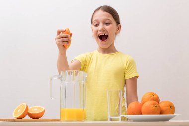 çocuk elleriyle portakal suyu sıkıyor