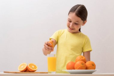 çocuk elleriyle portakal suyu sıkıyor