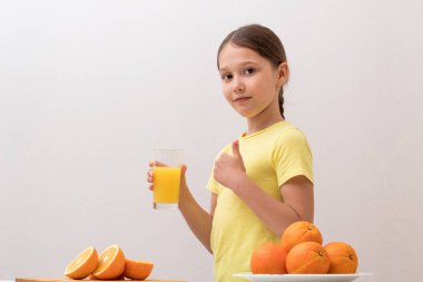 Güzel küçük kız portakal suyu içiyor. Sevinç kavramı bir