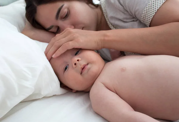 Beautiful brunette girl hugs and plays with baby. The concept of — Stock Photo, Image