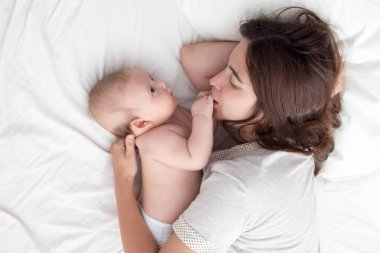 Güzel esmer kız kucaklar ve bebek ile oynar. Kavramı