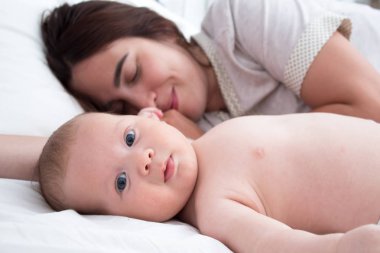 Güzel esmer kız kucaklar ve bebek ile oynar. Kavramı