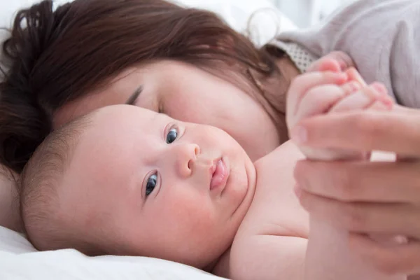 Gyönyörű barna lány ölelést és játszik a babát. A — Stock Fotó