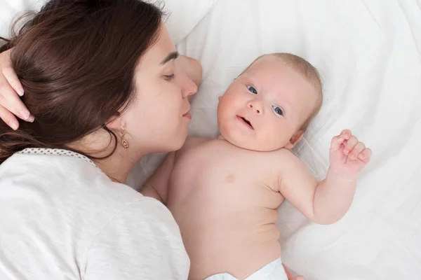 Vacker brunett flicka kramar och leker med baby. Begreppet — Stockfoto