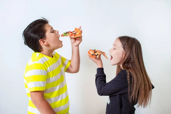 Мальчик и девочка едят пиццу. Дети обедают. — стоковое фото